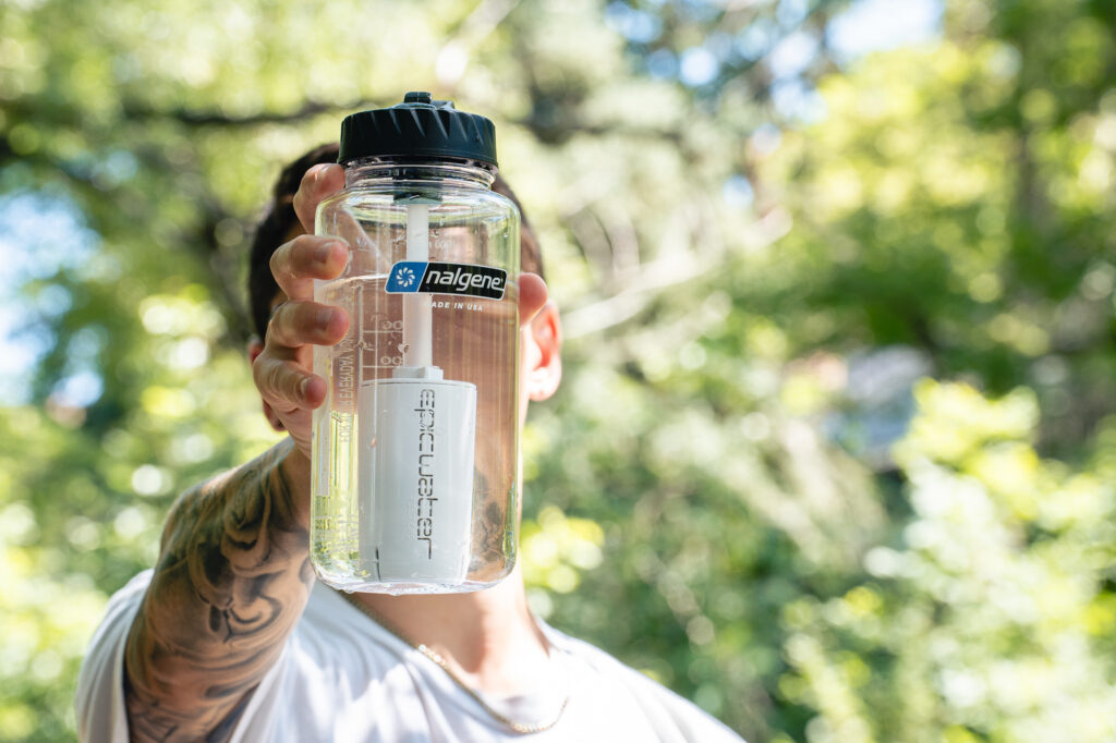 A person holds a Nalgene water bottle