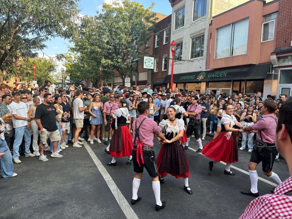 oktoberfest-south-street-2024-1 a crowd looks at dancers in the street