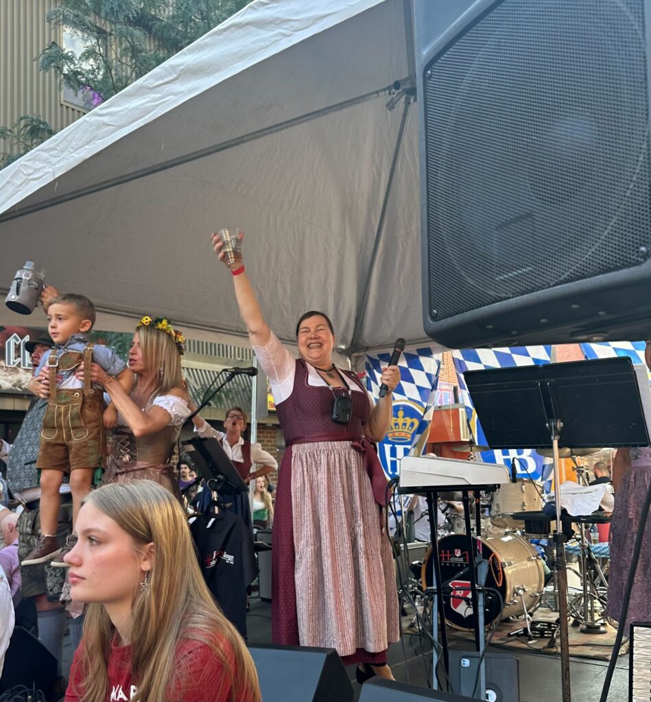 Karen David onstage holds up a beer