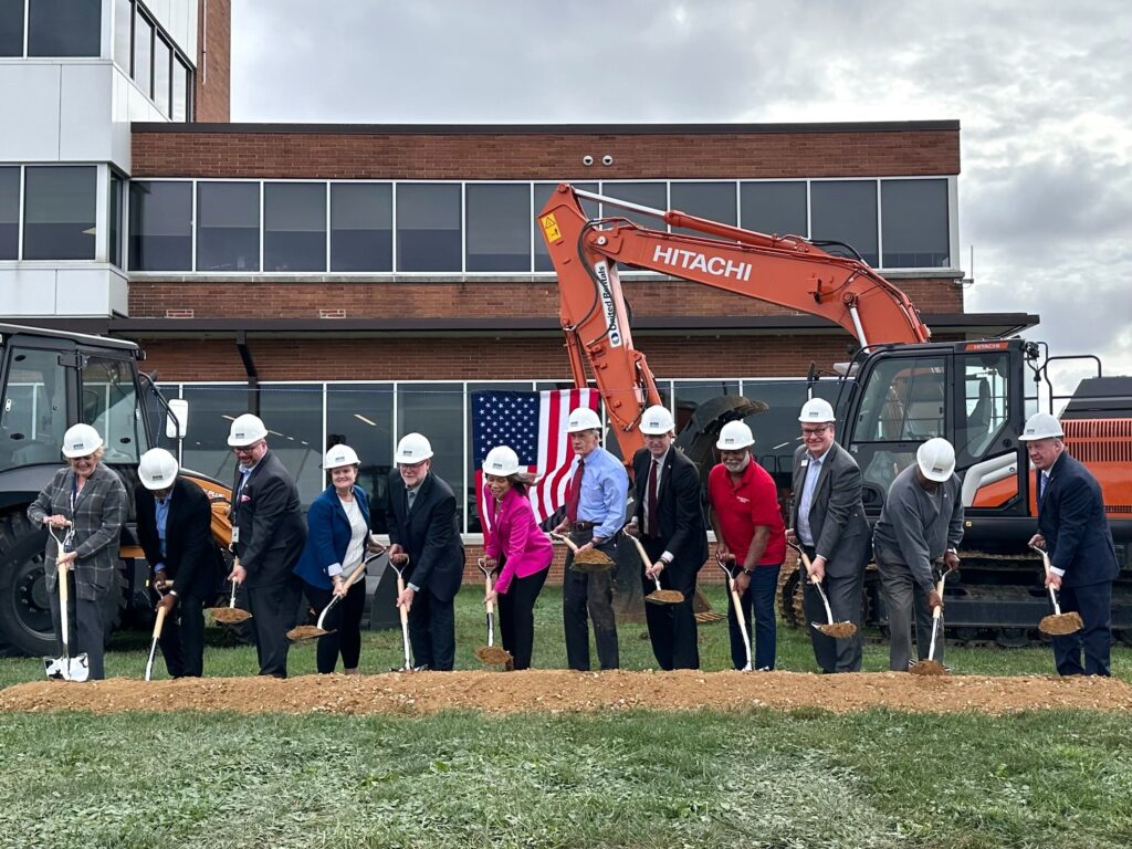 people ceremoniously hold shovels