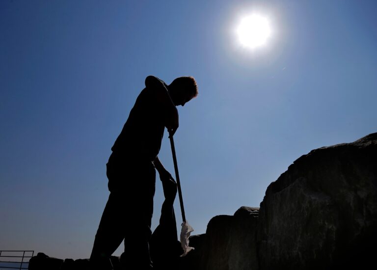 a person holds a shovel in the sun