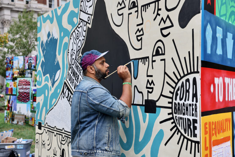 Man paints a mural at Love Park