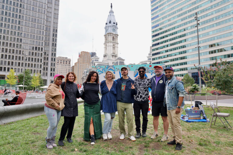 Six artists made murals for this year's ''To The Polls'' exhiibit in Love Park. Pictured are (from left) Serena Saunders, Mural Arts Executive Director Jane Golden, Isabella Akhtarshenas, Nicole Nikolich, curator Conrad Benner, Alloyius McIlwaine, Hawk Krall, and Jeffy Thomas. (Emma Lee/WHYY)
