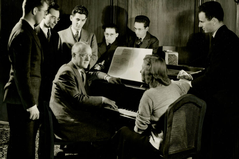 Leonard Bernstein at a piano with others
