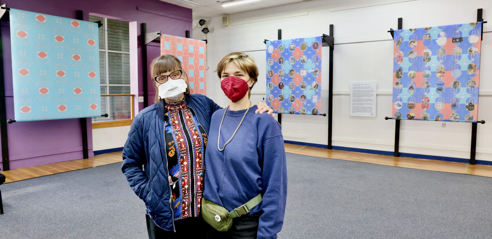 Maggie Mills and Shannon Brooks wear masks and side-hug