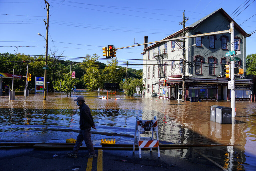 Tropical Weather Atlantic A person walks on a flooded street