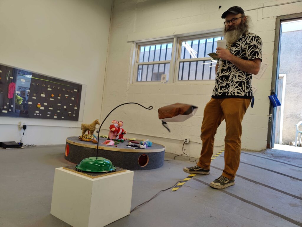 IMG20241024161552 Gallery co-founder Chris Hammes demonstrates a puppet duck spinning on a motorized hook by Ollie Goss. (Peter Crimmins/WHYY)