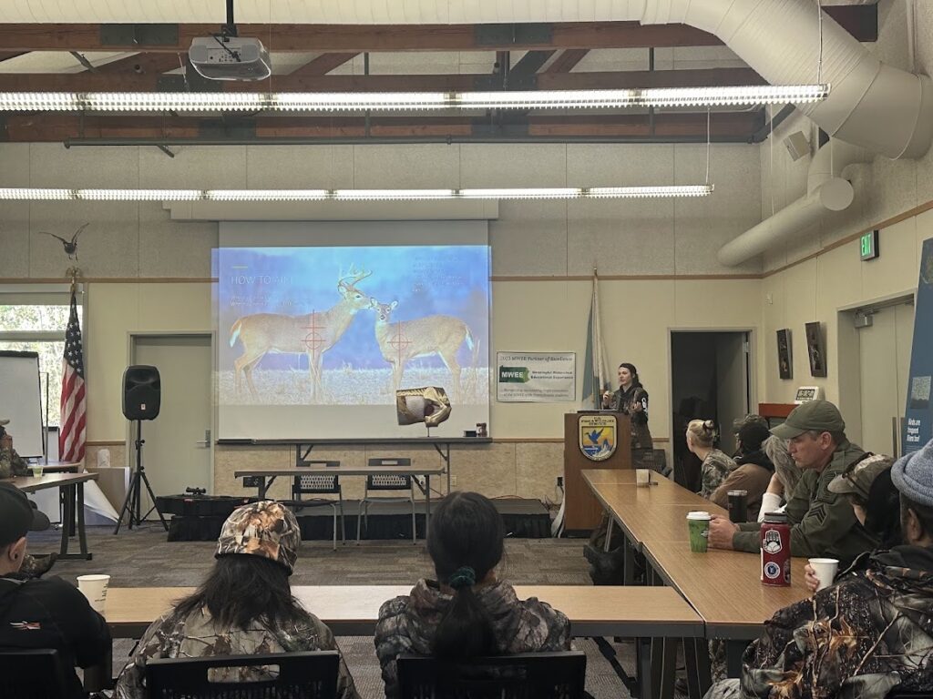 john_heinz_refugee1 Woman shows people on a projector where to shoot a deer