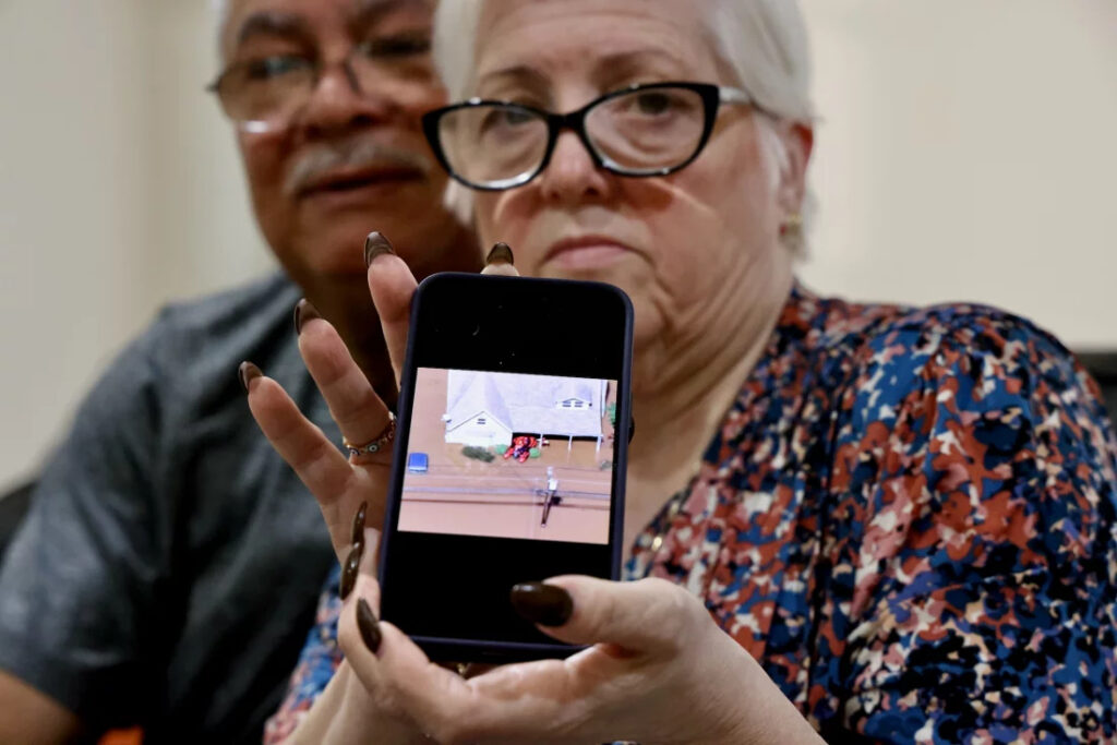 Miriam Saladin, next to her husband, shows a photo from her phone
