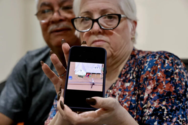Miriam Saladin, next to her husband, shows a photo from her phone