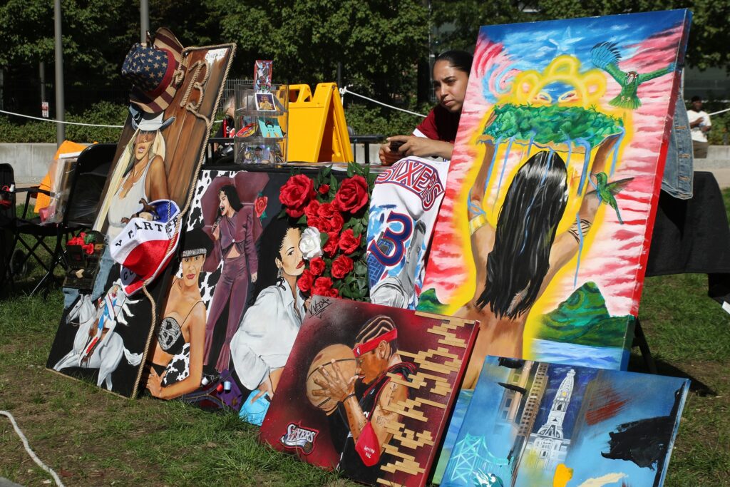 mural-arts-festival-2024-10-06-10 an artist selling multiple painting