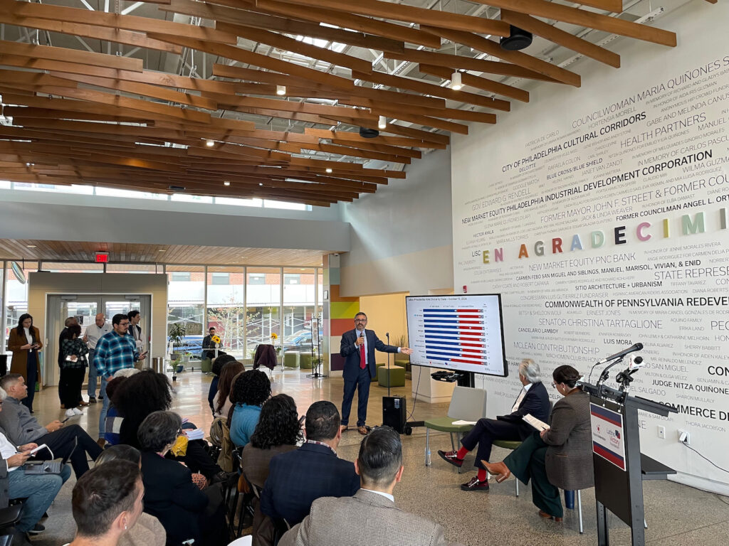 taller-latino-vote-event – 1 Group looks at the results of a poll on a TV