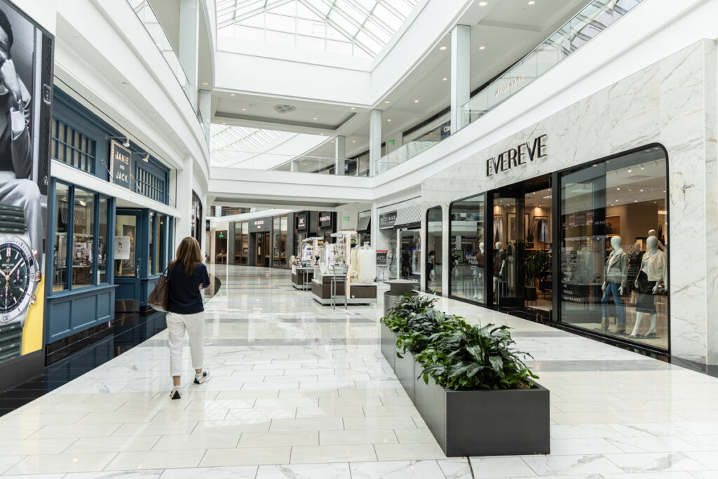 Inside the mall, with only one person walking by the stores