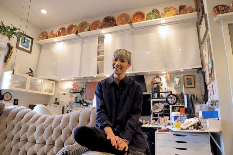 Composer Melissa Dunphy sits in her living room, adorned with the 18th century pottery that she excavated from the ground below her house on Callowhill Street. (Emma Lee/WHYY)