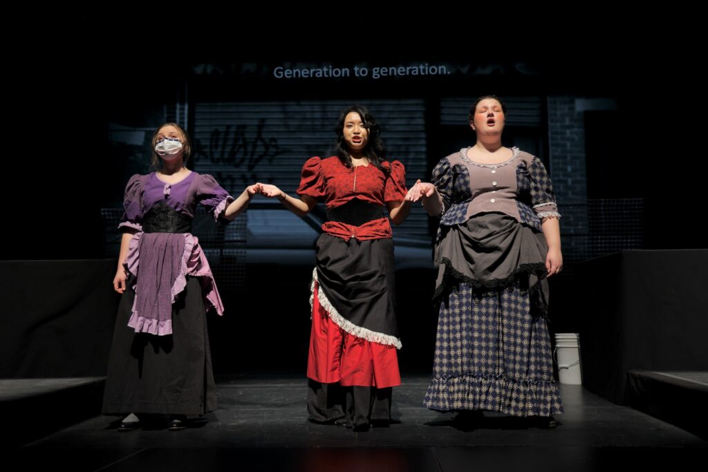 Three versions of Alice Tierney, portrayed by (from left) by Niamh Kelly, HaYoung Nam, and Anastasia Groden, perform on stage at West Chester University's Asplundh Concert Hall during a rehearsal for Melissa Dunphy's opera about the 19th century murder of a sex worker in Philadelphia. (Emma Lee/WHYY)