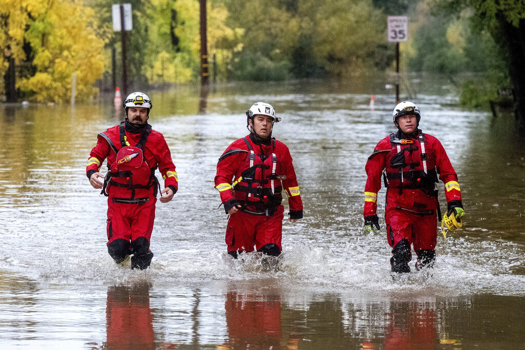 US Severe Weather Firefighters walk through floodwaters while responding to a rescue call in unincorporated Sonoma County, Calif., on Friday, Nov. 22, 2024. (AP Photo/Noah Berger)