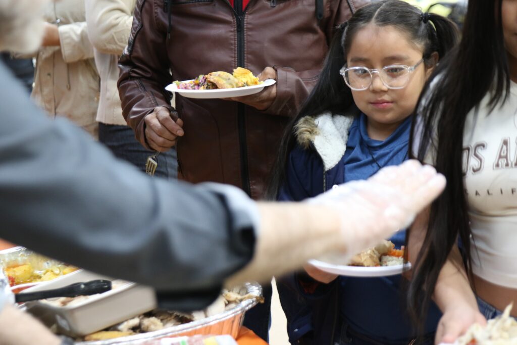 Old-Pine-Community-Center-thankful-together-2024-17 a child receives a plate of food