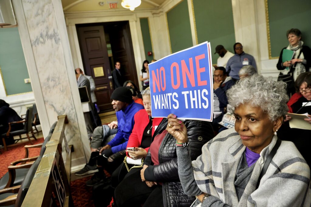a sign held by an audience member reads no one wants this