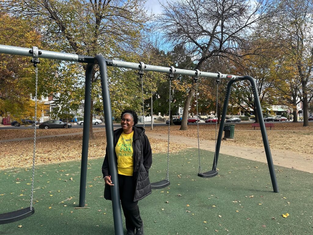 Cheri Harrison smiles next to swings