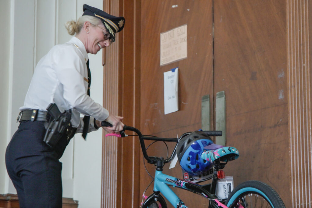 12 05 2024 k paynter temple police holiday bike giveaway-3 Jennifer Griffin smiles and holds a bike