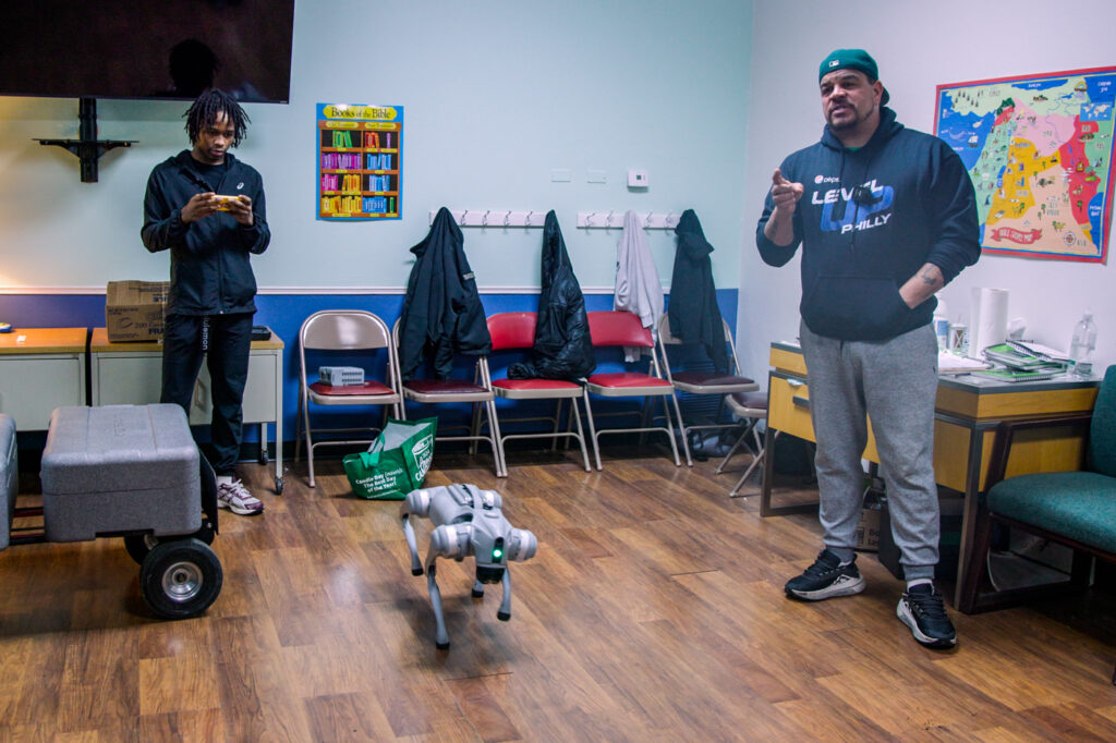 12 24 2024 k paynter level up philly-3 Aaron Campbell speaks next to Sybir Brown and a robotic dog
