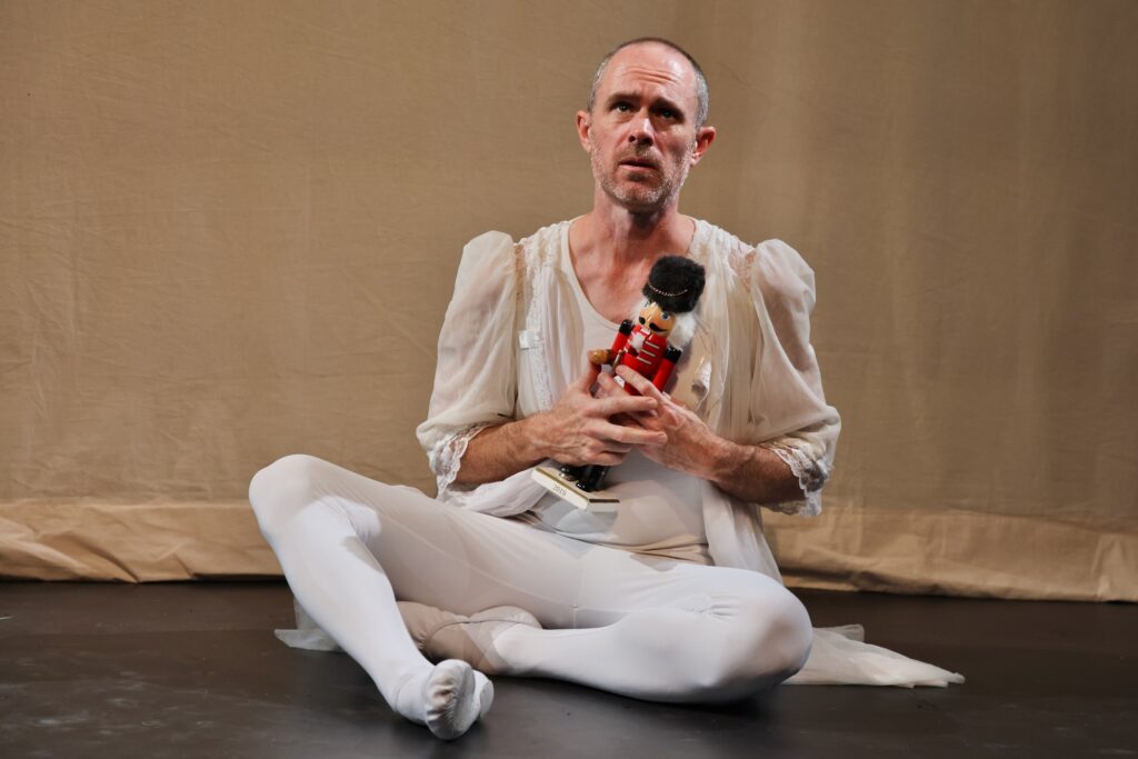 2024 12 09-e lee-chris davis-philadelphia the drake theater-one man nutcracker clara Chris Davis performing ballet while holding a nutcracker