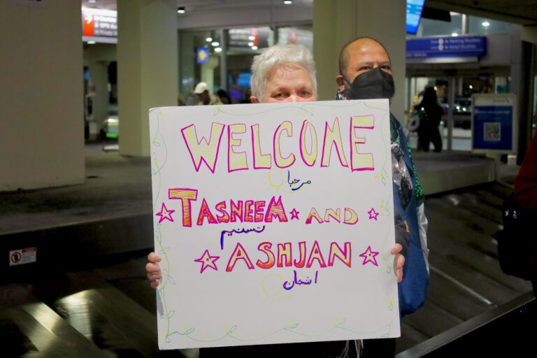 People holding up signs in the airport
