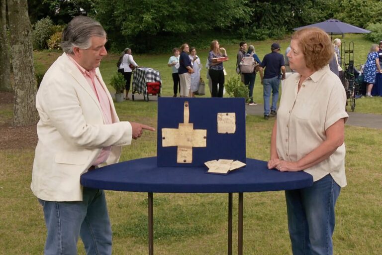 Joel Bohy appraising the artifacts next to Nanette Osborne