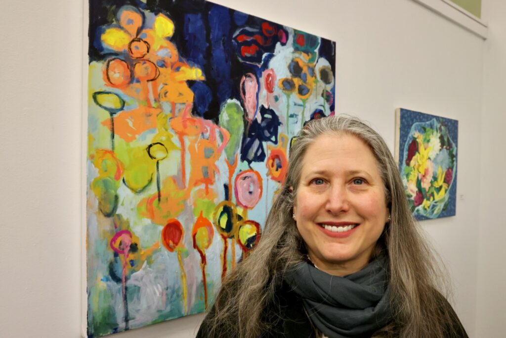 2024 12 18-e lee-erin elman-philadelphia city hall-transcending uncertainty exhibit uarts Erin Elman smiles next to her painting