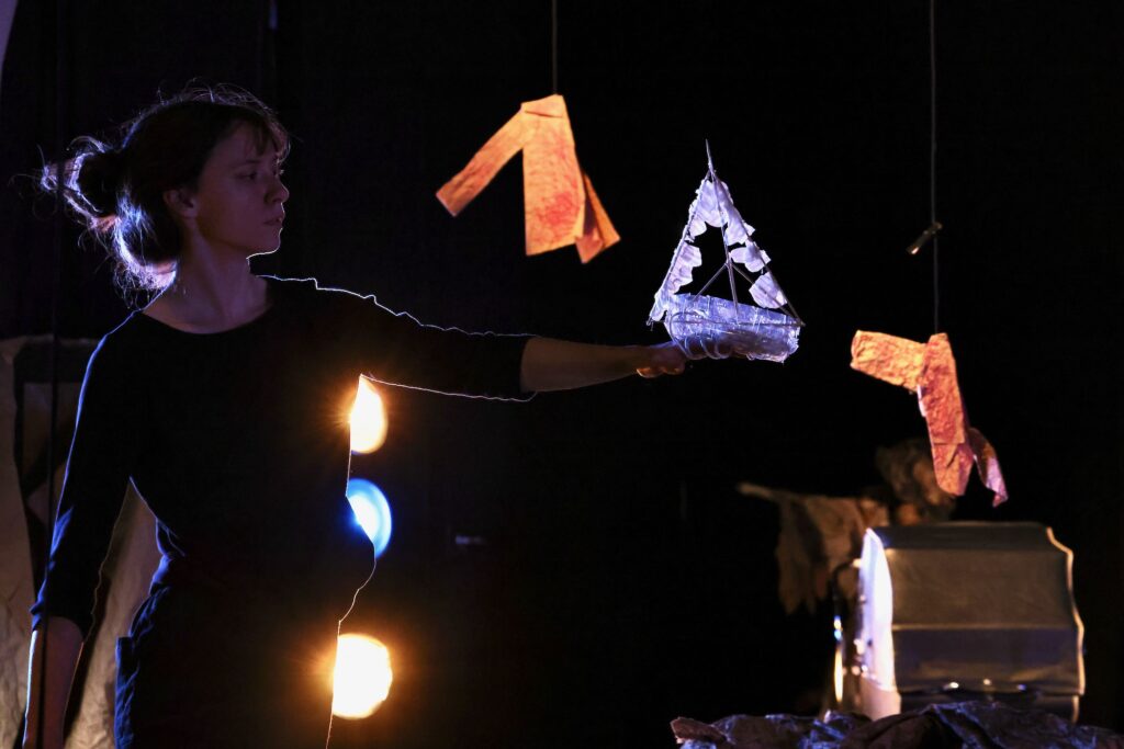2024 12 18-e lee-philadelphia theatre exile-tea and the ark light and shadow a light shines on an ark in a hand