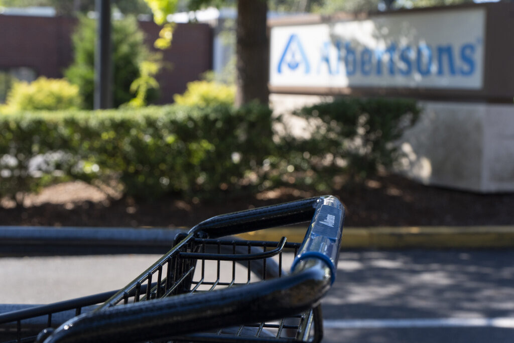 Kroger-Albertsons Merger FILE - A grocery cart rests in a cart return area with a sign for Albertsons grocery store in the background on Aug. 26, 2024, in Lake Oswego, Ore. (AP Photo/Jenny Kane, File)