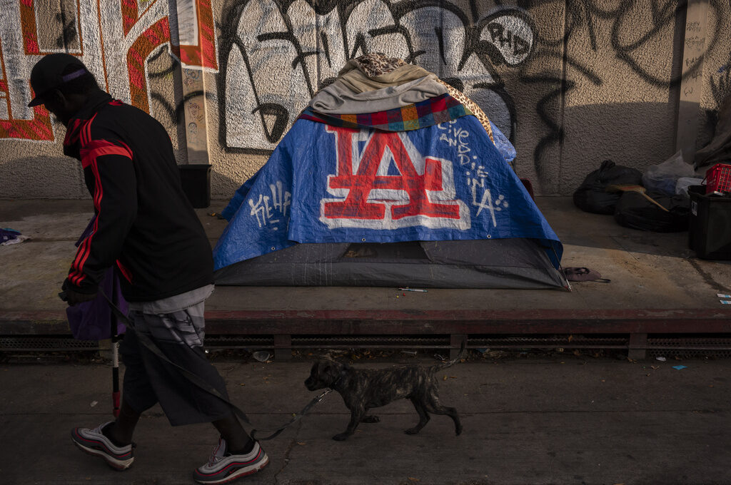 Homelessness FILE - A man walks past a homeless encampment in downtown Los Angeles, Wednesday, Oct. 25, 2023. (AP Photo/Jae C. Hong, File)