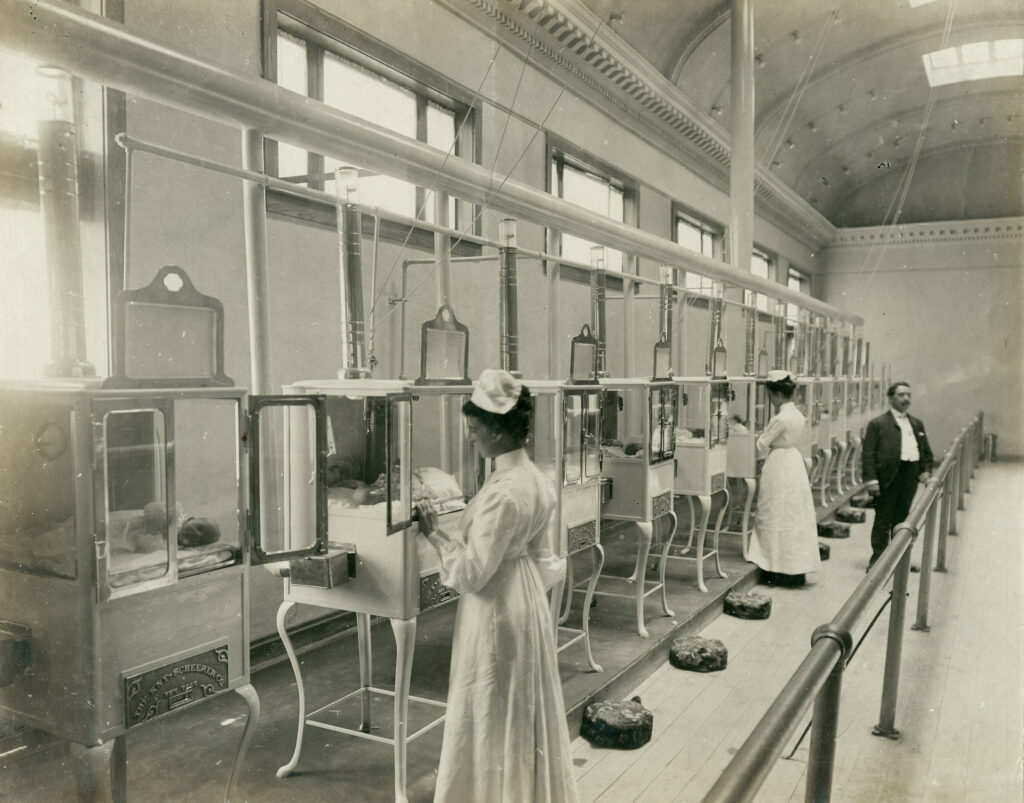 Manager,_Mr._E.M._Bayliss_and_nurses_attending_babies_in_the_Baby_Incubator_exhibit_on_the_Pike_at_the_1904_World’s_Fair In the U.S., baby incubators and neonatal intensive care units have their roots in a surprising place — sideshow carnivals. In this photo, taken by Jessie Tarbox Beals, nurses attend to babies at the 1904 World's Fair baby incubator exhibit. (Courtesy of the Missouri History Museum via Wikimedia Commons)