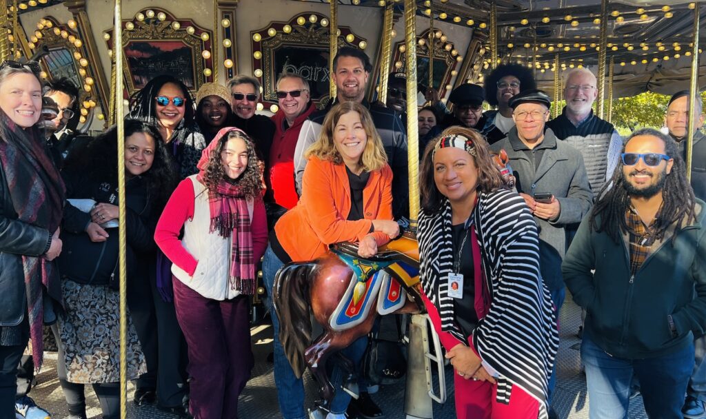 WHYY News staff participate in a team building exercise including the merry-go-round and mini-golf at Franklin Square Park.