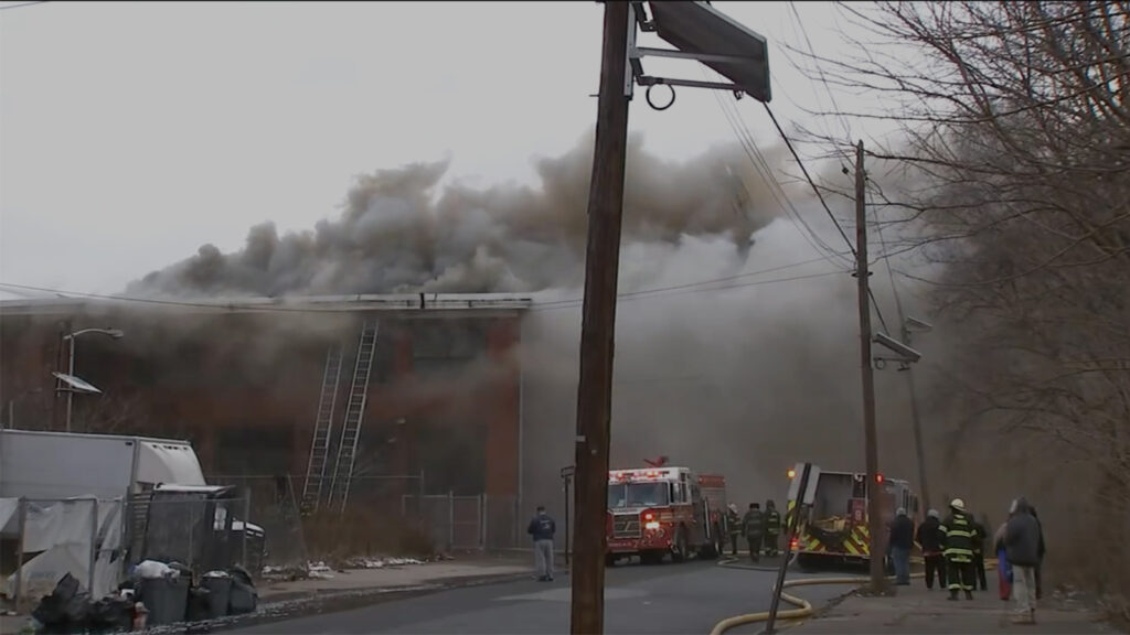 camden_fire Smoke pours out of a building in front of a group of firefighters