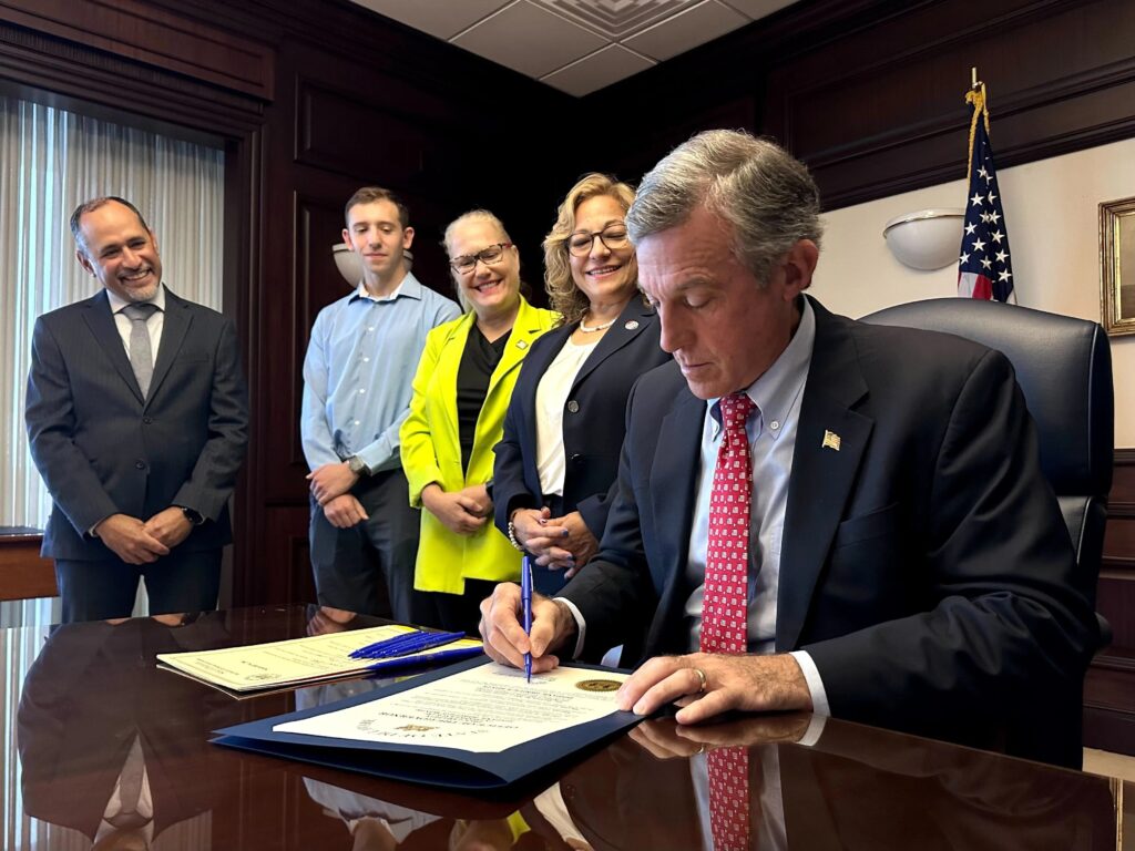 delaware-governor-john-carney-2024-09-26-legislation John Carney signing legislation as four others look on