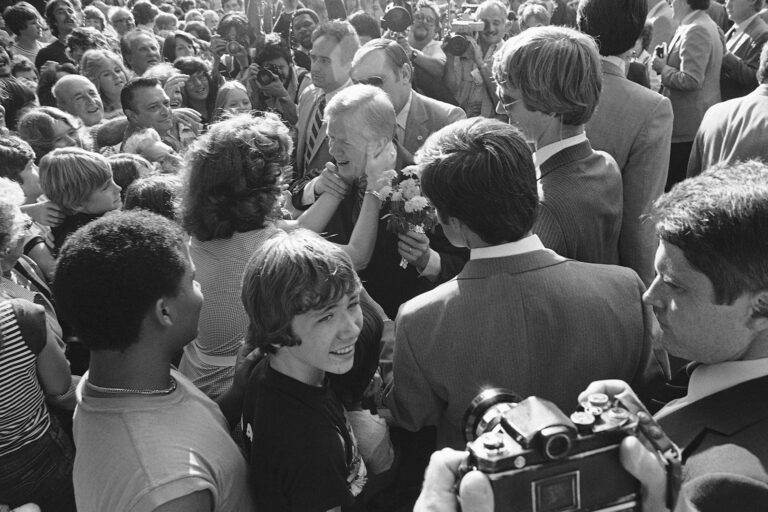 A Secret Service Agent helps U.S. President Jimmy Carter pull away from an unidentified woman who kissed him while he visited a family in suburban Lansdowne, Pennsylvania, Thursday, Oct. 2, 1980. Carter was spending part of Thursday in the Philadelphia campaigning for a second term.