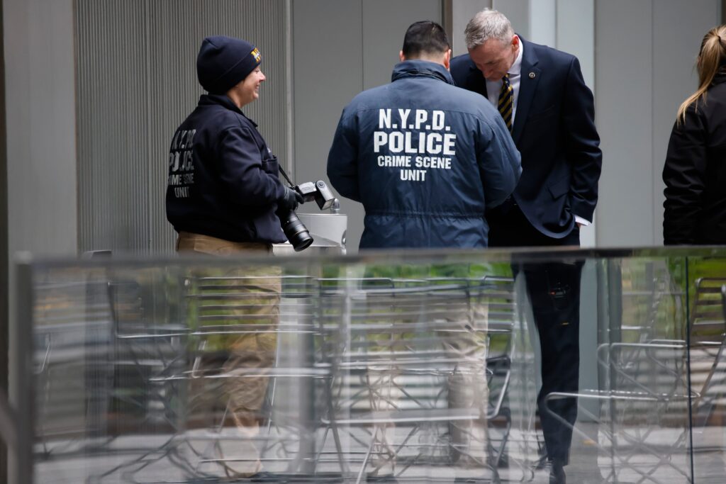 unitedhealthcare-ceo-ghost-gun Members of the New York police crime scene unit investigate the scene outside the Hilton Hotel