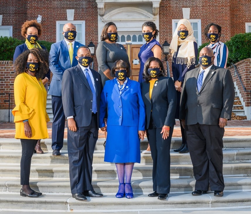 A group of Black lawmakers pose for a photo outside on the steps