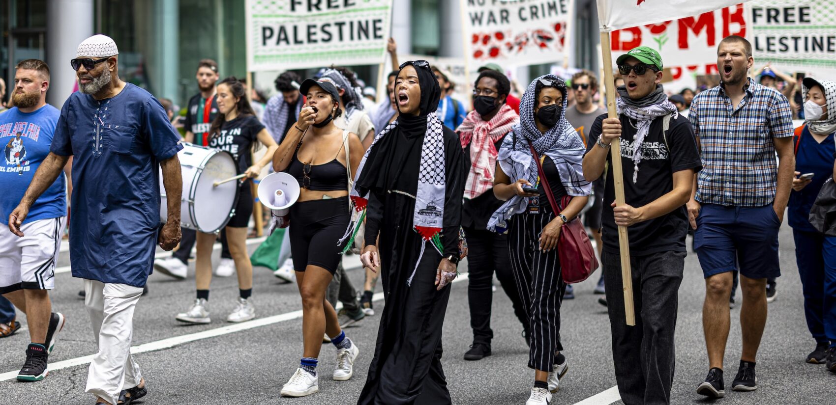 Protesters march through the street with signs sying 'Free Palestine'