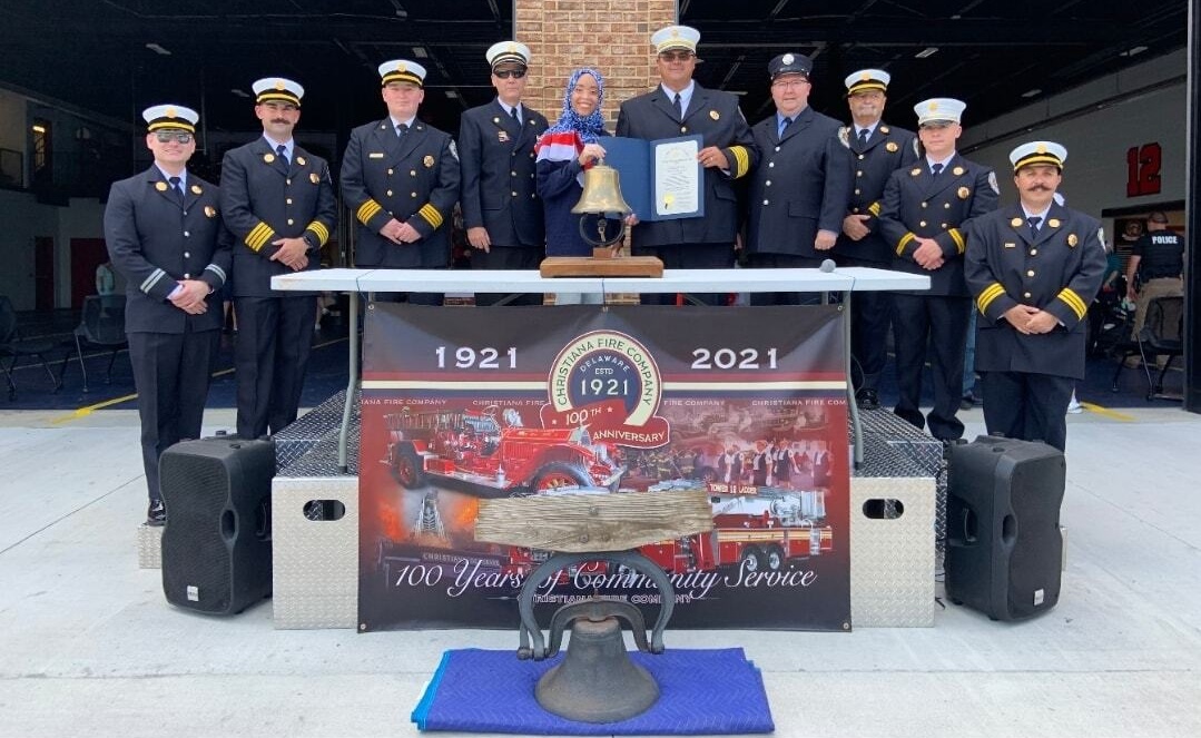 Wilson-Anton posing for a photo with a group of firefighters