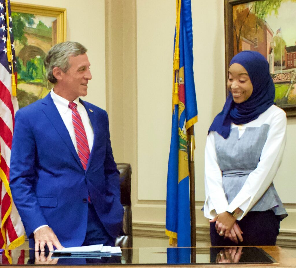 Wilson-Anton smiling while taking a photo with Gov. John Carney