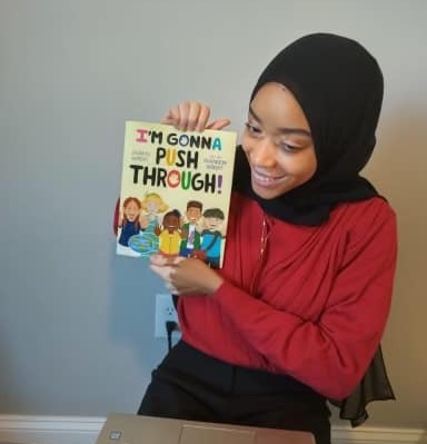 Wilson-Anton holding up a children's book