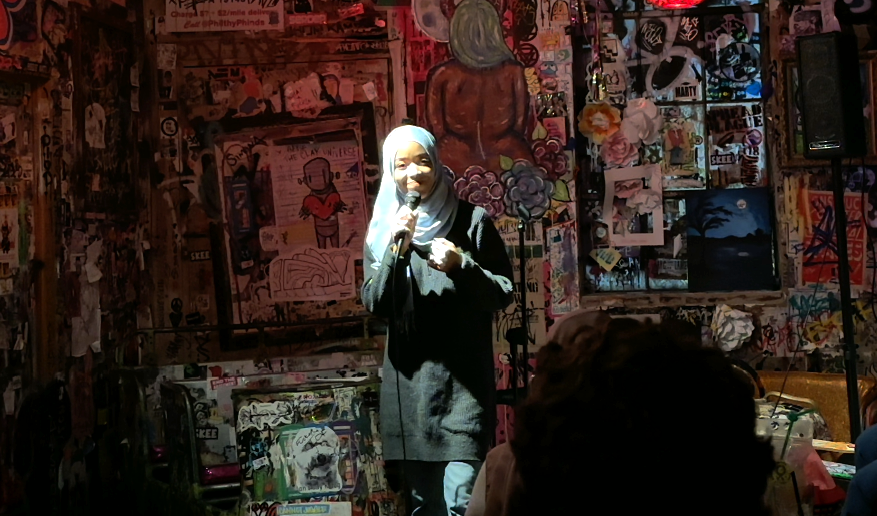 Madinah Wilson-Anton on stage performing her comedy routine