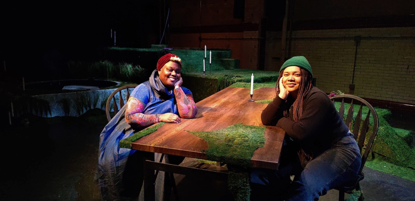 Arielle Julia Brown and Nia Benjamin sit and smile
