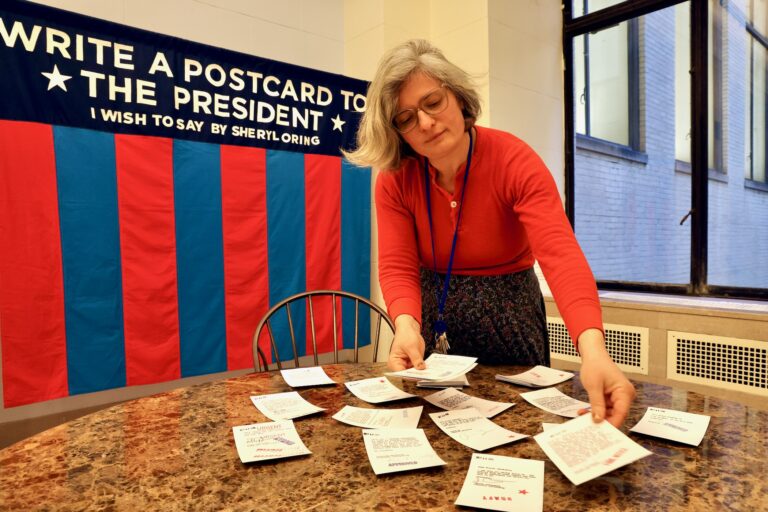 A woman displays postcards sent to United States presidents