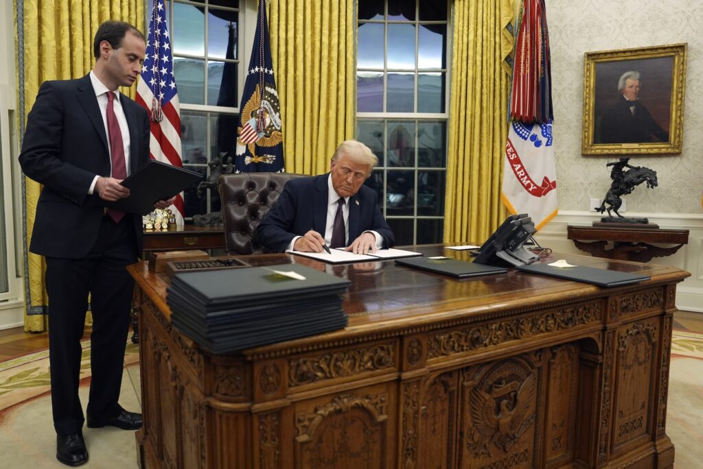 Donald Trump Trump signing an oder at his desk in the oval office