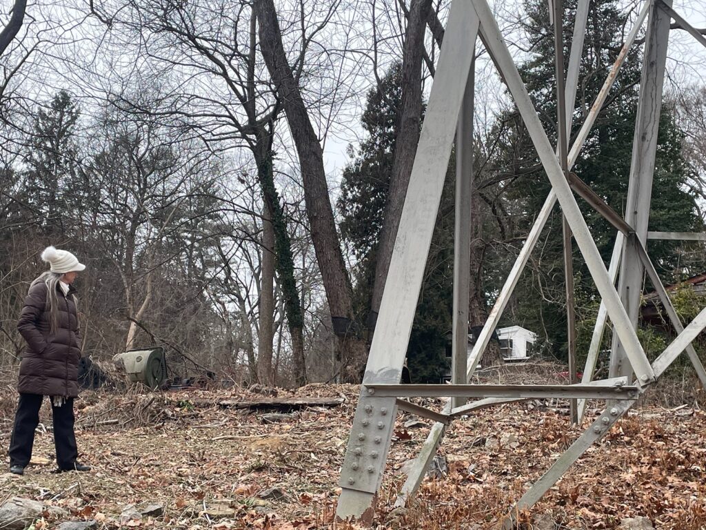 arden-delaware-electric-lines-controversy-2025-5 Lisa Wilson Riblett looks at the base of a tower