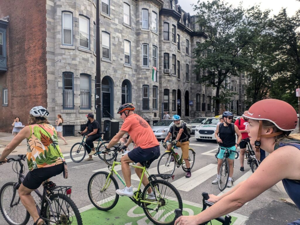 Several people on bicycles block a busy intersection