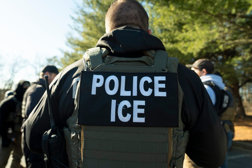 ice-agent-2025-01-27 an ICE agent wears a vest reading POLICE ICE